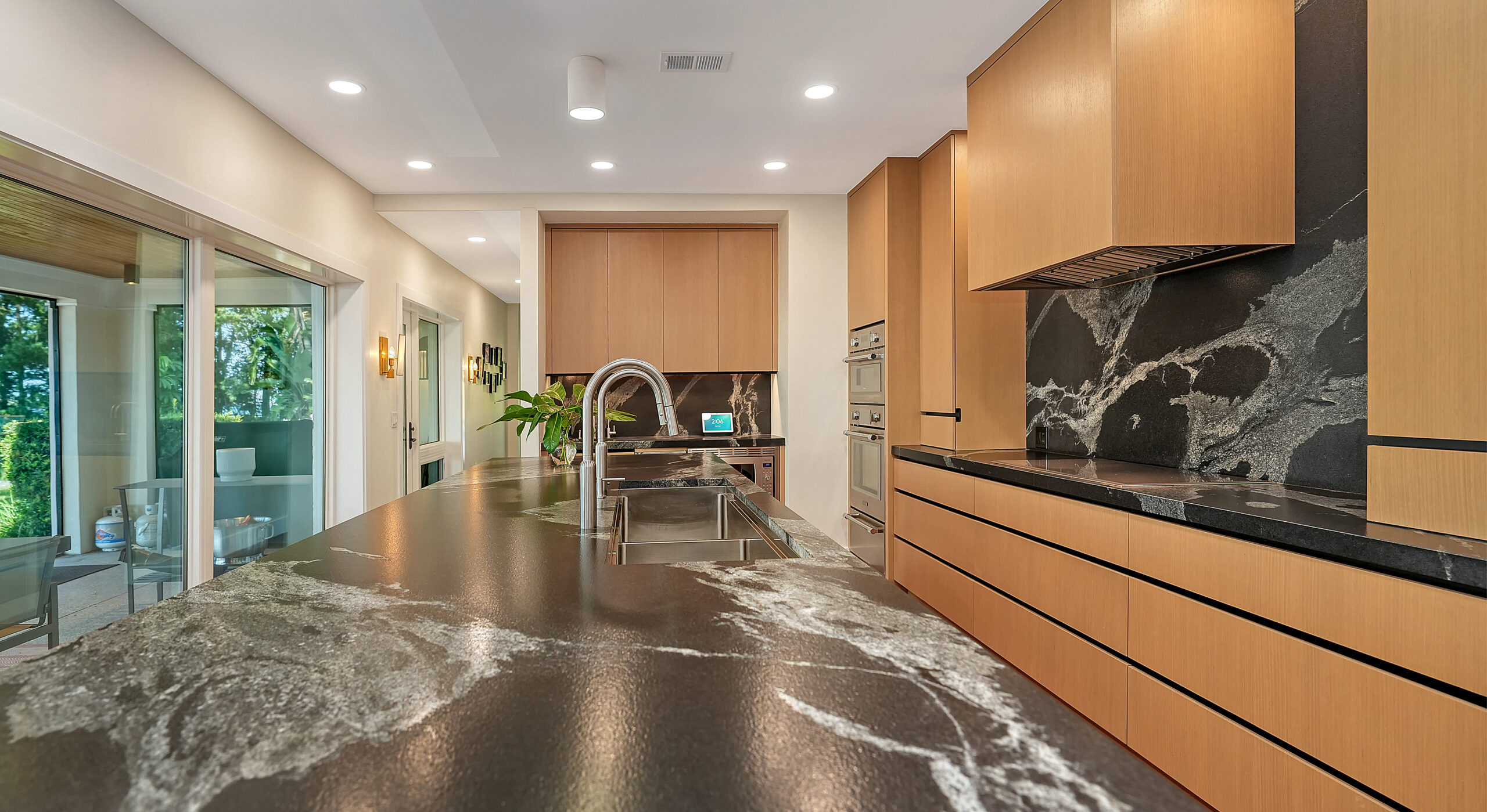 Metro Cabinet Company kitchen with stone counters opening to a garden terrace