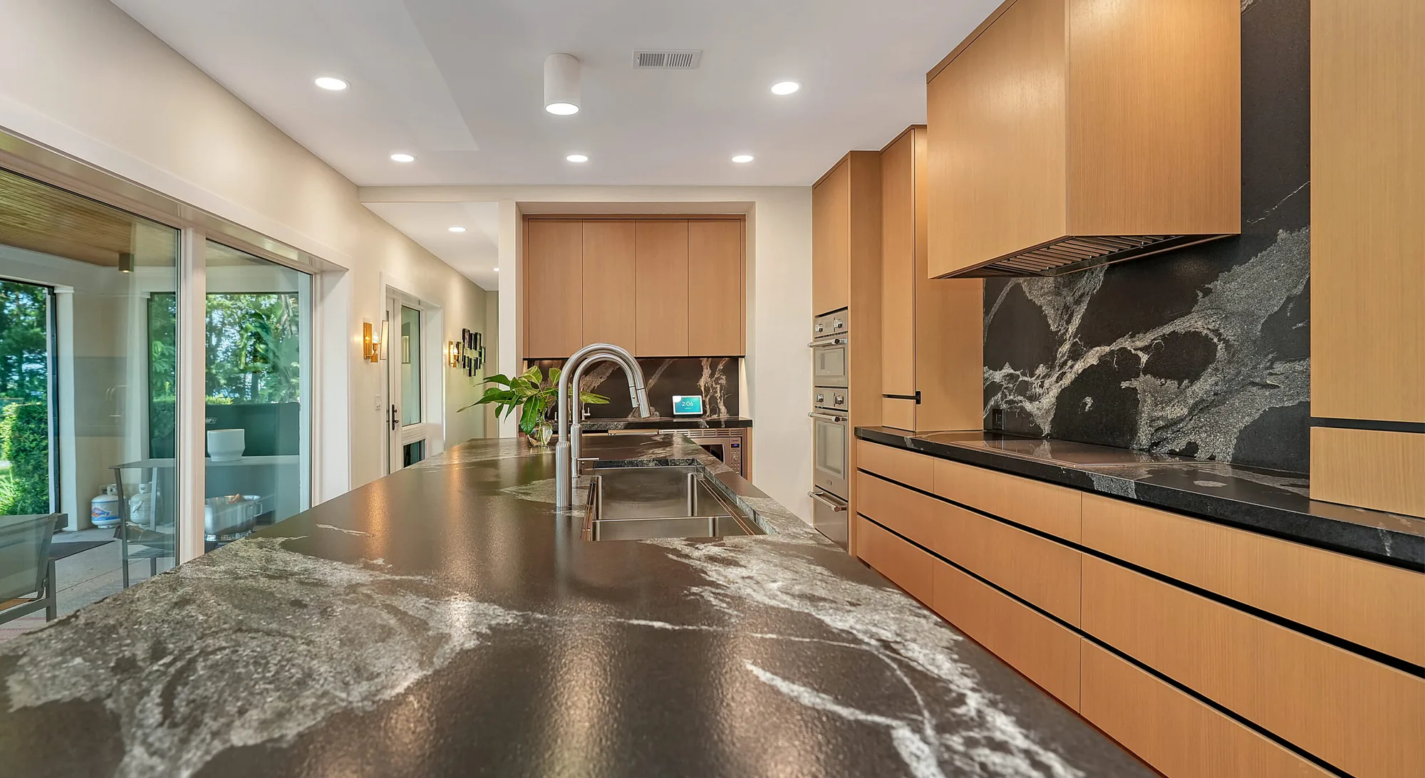 Metro Cabinet Company kitchen with stone counters opening to a garden terrace
